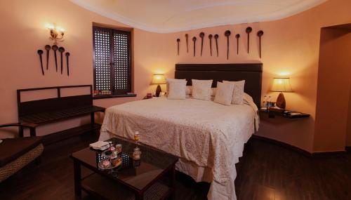 焦特布尔The Ajit Bhawan - A Palace Resort的卧室配有一张带白色床单和枕头的大床。