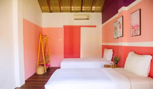 Hiếu XươngLumiere Family Village Dong Tac的配有粉红色和白色墙壁的客房内的两张床