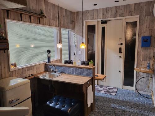 志摩市Seaside Garage Shima - Vacation STAY 77073v的厨房设有木墙、水槽和窗户