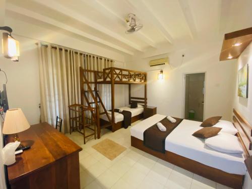 阿努拉德普勒Sadula Holiday Resort的一间卧室配有两张床和一张双层床。