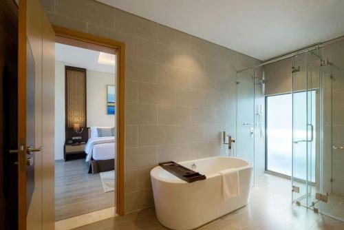 金兰市Residence Inn Villa Cam Ranh的带浴缸的浴室和卧室
