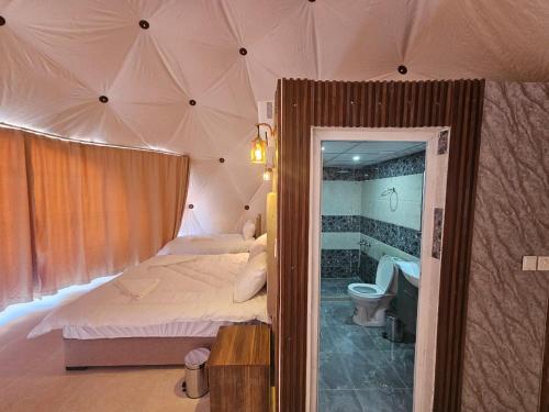 瓦迪拉姆غرووب وادي رم的一间卧室配有一张床,帐篷内设有一个浴缸
