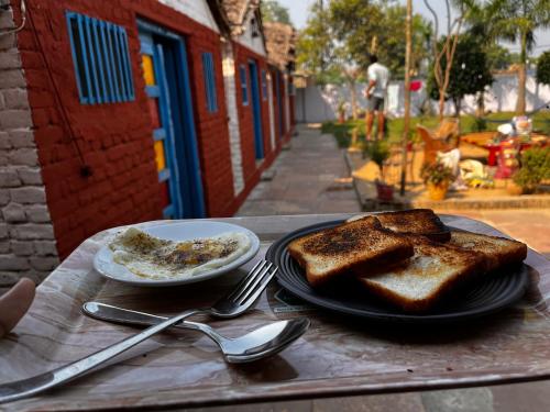 阿格拉Backpackers Village Agra的一张桌子,上面放着烤面包和一盘食物