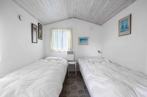 MesingeCharming Cottage In Mesinge的白色墙壁客房的两张床