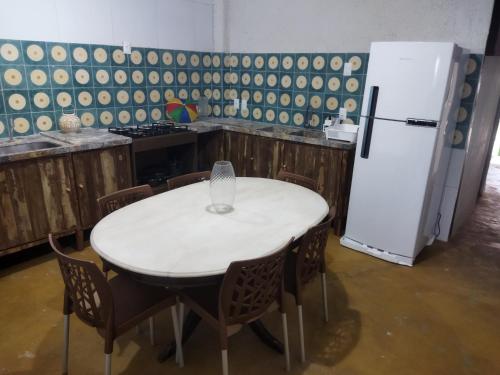 奥林达Casa Prudente的厨房配有白色的桌子和冰箱。