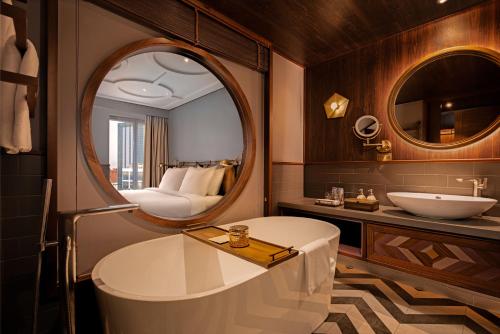 胡志明市Fusion Original Saigon Centre的带浴缸、水槽和镜子的浴室