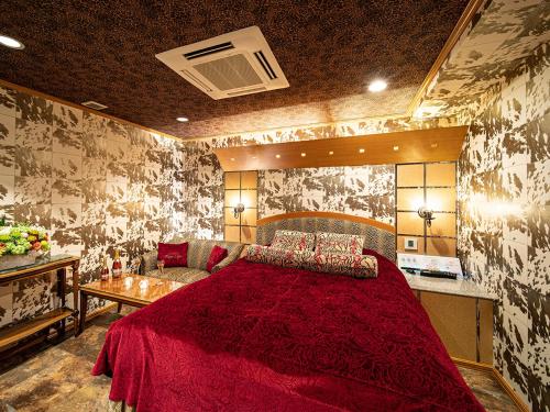 大阪Rose Lips Shinsaibashi ローズリップス心斎橋的一间卧室配有一张红色的大床和一张沙发