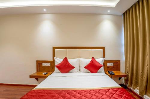 班加罗尔FabHotel Phoenix Horamavu的一间卧室配有一张带红色枕头的大床