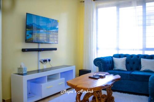 NyahururuMupa's Luxury Condo II的客厅配有蓝色的沙发和茶几