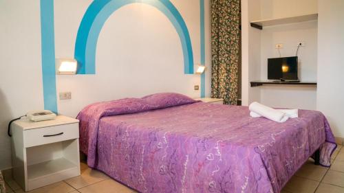 托尔托雷托Villaggio Welcome Riviera d'Abruzzo的一间卧室配有一张带紫色棉被的床