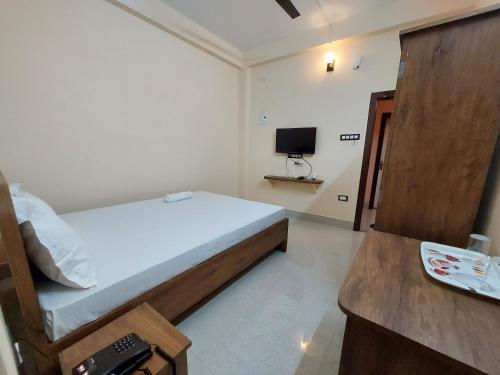 古瓦哈提Hotel Hari Gayatri Regent的一间卧室配有一张床和一台电视
