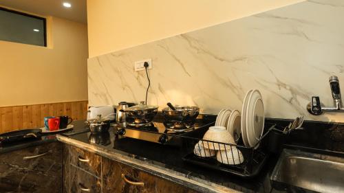 达兰萨拉Himalayan Suite的厨房柜台配有炉灶和水槽