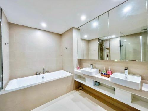 头顿The Song Vung Tau By Abogo的浴室设有2个水槽、浴缸和镜子
