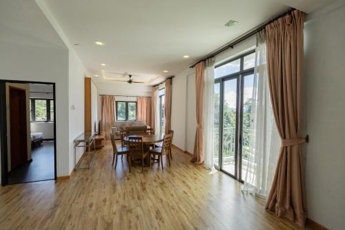 金马仑高原Hills Aranda Nova Hotel的用餐室以及带桌椅的起居室。
