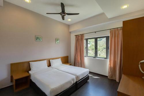 金马仑高原Hills Aranda Nova Hotel的一间卧室配有一张床和吊扇