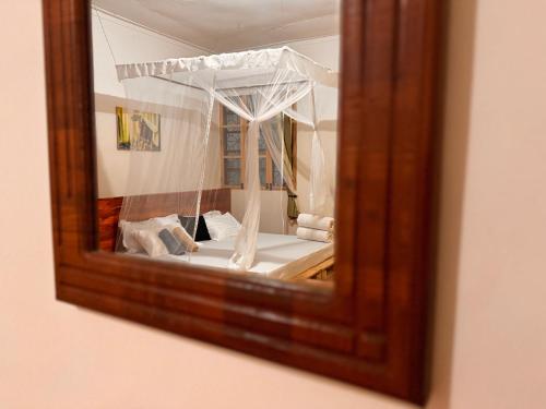 莫希Karibu Africa Home的镜子反射着房间里的床