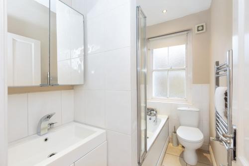 伦敦Beautiful 2BR Flat, Peaceful Dulwich, South London的白色的浴室设有水槽和卫生间。
