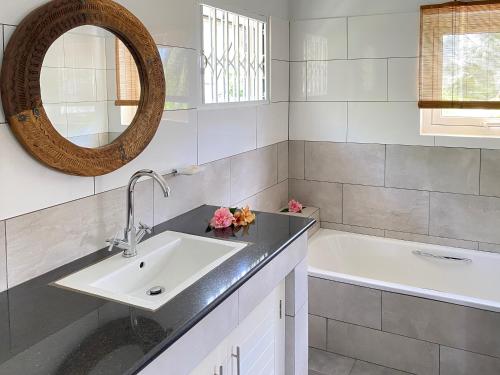 塔卡马卡布干维尔木屋的一间带水槽、浴缸和镜子的浴室