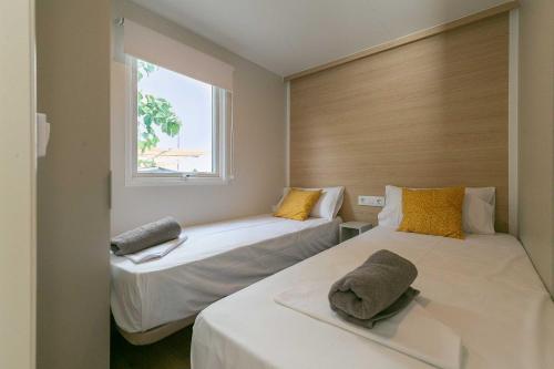 奇尔切斯Camping tres estrellas Mediterráneo的一间卧室设有两张床和窗户。