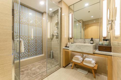 济南润华世纪酒店(济南西站国际会展中心店)的带淋浴、盥洗盆和镜子的浴室