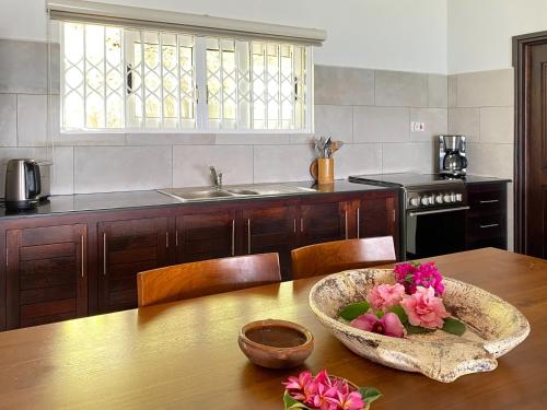 塔卡马卡布干维尔木屋的厨房里摆放着一碗鲜花,桌子上放着一碗