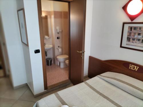 布雷西亚黛拉沃尔塔酒店的一间卧室配有一张床,浴室设有卫生间