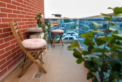 沃伦塔里Urban Bliss - Contemporary Elegance in Modern Living Spaces的砖墙阳台配有两把椅子和一张桌子