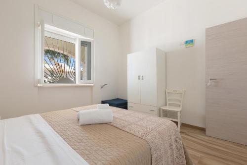 圣伊西多罗Villino delle Orchidee by BarbarHouse的白色的卧室设有床和窗户