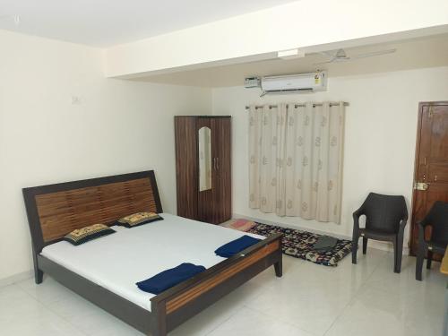 达波林Sai Leela Guest House的一间卧室配有一张床和两把椅子