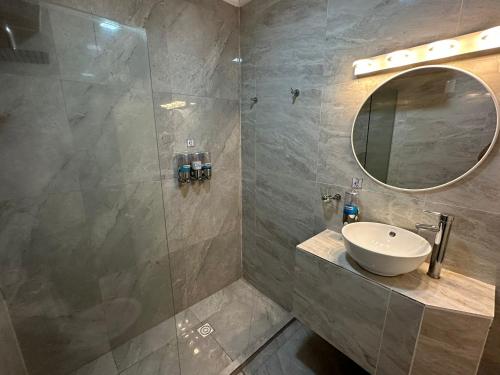 皮里亚波利斯卢汉酒店的浴室配有盥洗盆和带镜子的淋浴