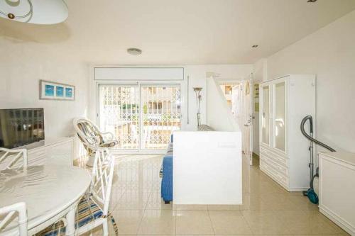 罗萨斯106casa bocana inmo apartaments roses的白色的厨房配有桌子和冰箱