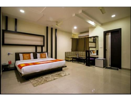 占西Hotel Bundelkhand Pride, Jhansi的一间带大床的卧室和一间浴室