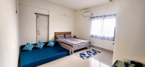 迈索尔Rent On Comfort Luxury Room的一间设有蓝色沙发和窗户的客房