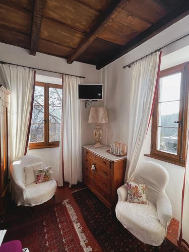 比戈尼奥Grotto Flora B&B Chambres de charme的客房设有2把椅子、书桌和窗户。