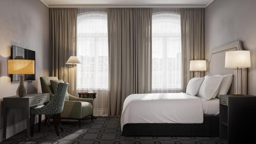 斯塔万格Hotel Victoria的酒店客房带一张床、椅子和窗户