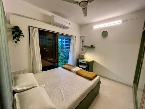 孟买La Olive 1 BHK Service Apartment的一间小卧室,配有床和窗户