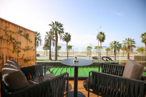 伏罗拉Charm Hotel的一个带椅子和桌子的庭院,并种植了棕榈树