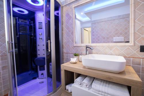 奥尔比亚Blue Island - Luxury House的浴室配有盥洗盆和带镜子的淋浴