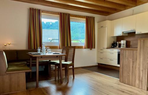 HintergöriachLandhotel - Apartments Bauer的厨房以及带桌椅的用餐室。