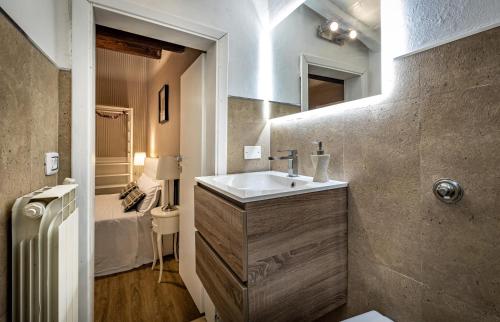 佛罗伦萨Florentine Experience in Santa Croce的一间带水槽的浴室和一张位于客房内的床