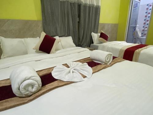 巴拉特布尔Hotel Kavya Inn的两张位于酒店客房的床,配有毛巾