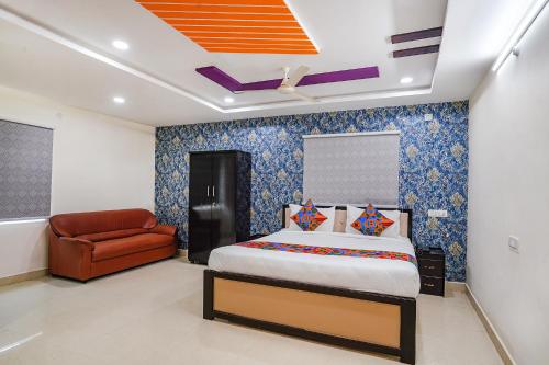 海得拉巴FabHotel Sri Karthikeya Grand的一间卧室配有一张床和一张红色椅子