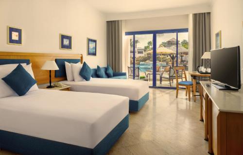 沙姆沙伊赫Jaz Fayrouz的酒店客房设有两张床和电视。