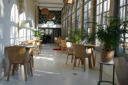 里摩日Les Chambres du Cloître的用餐室设有桌椅和窗户。