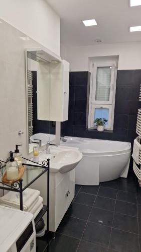 贝凯什乔包Martina apartman Békéscsaba的白色的浴室设有浴缸和水槽。