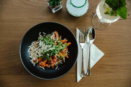 萨尔茨堡附近奥伯恩多夫Hotel Gleiserei的桌上放着一碗黑饭,上面放着米饭和蔬菜