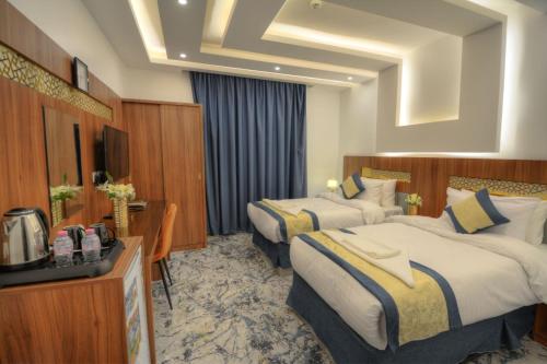 麦地那فندق المرزم-Al Marzam Hotel的酒店客房设有两张床和电视。
