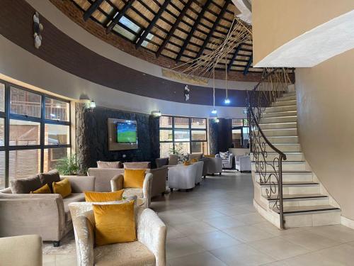 KingsmeadLovely safari room in Harare - 2181的大楼内一间设有沙发和楼梯的餐厅