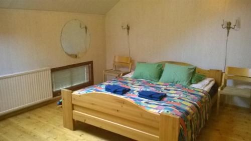 KauhajokiSuvannonrannan Majoitukset的一间卧室配有一张带绿色枕头的木床。