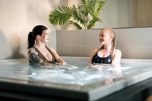 拉彭兰塔Hotelli Lähde的两名妇女坐在热水浴缸中
